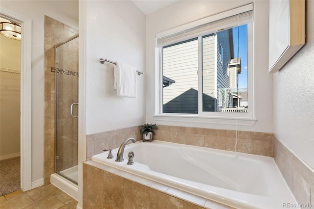 bathroom with shower with separate bathtub and plenty of natural light