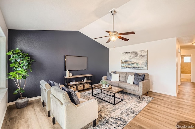 living room with ceiling fan, vaulted ceiling, and light hardwood / wood-style flooring