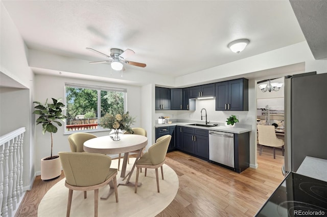 kitchen with blue cabinets, stainless steel appliances, sink, ceiling fan, and light wood-type flooring