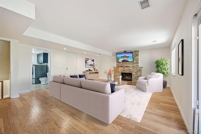 living room with light wood-type flooring and a fireplace