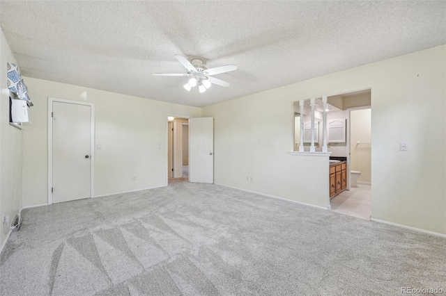 carpeted spare room with a textured ceiling and ceiling fan