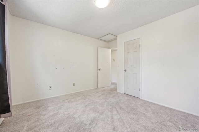 empty room featuring a textured ceiling and carpet flooring