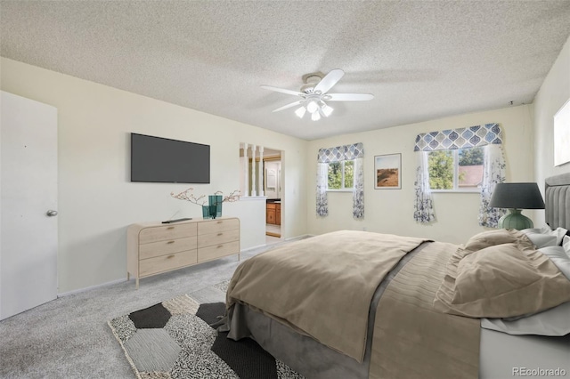 carpeted bedroom featuring ceiling fan and a textured ceiling