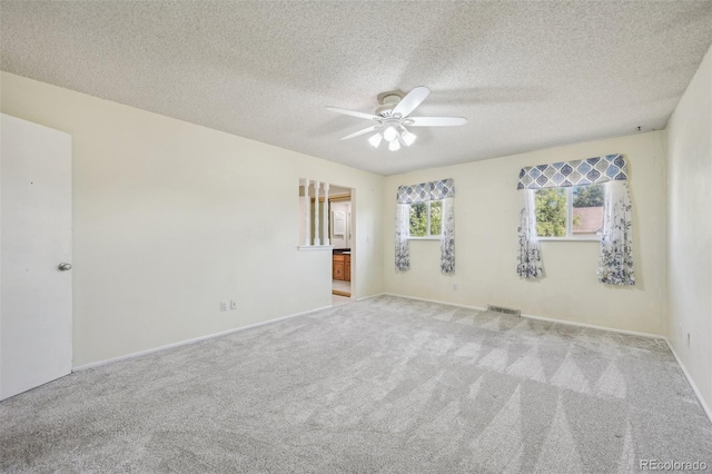 carpeted empty room featuring a textured ceiling and ceiling fan