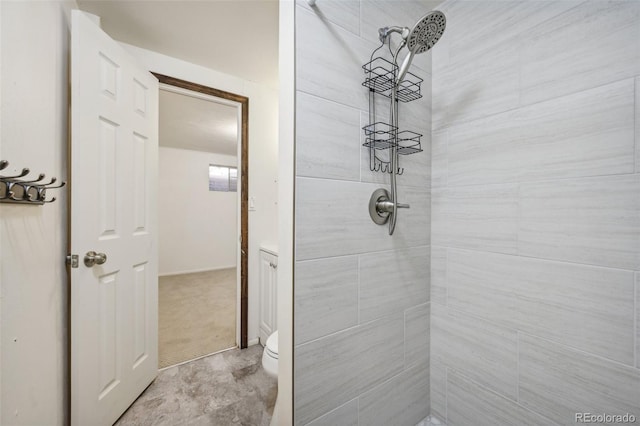 bathroom featuring tiled shower, tile patterned flooring, and toilet