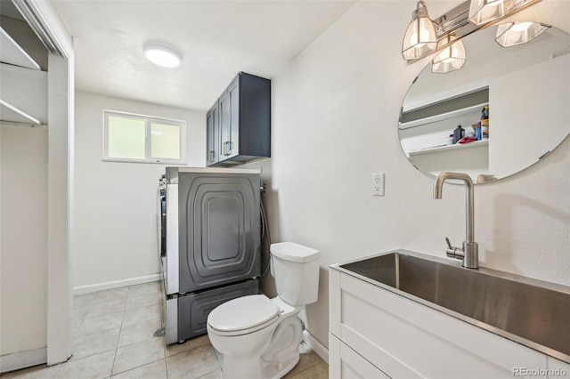 bathroom with washer / dryer, vanity, toilet, and tile patterned floors