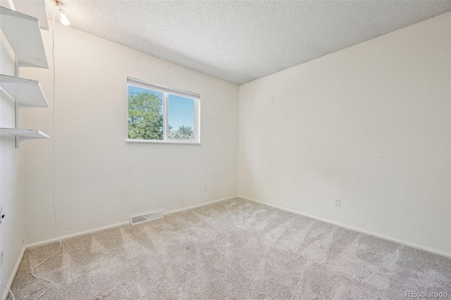 empty room with carpet and a textured ceiling