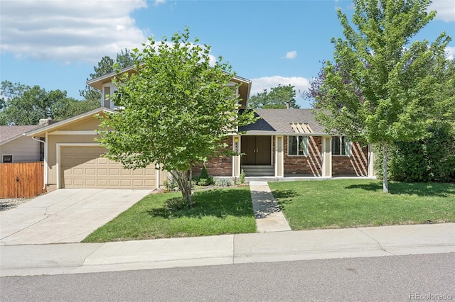 view of property hidden behind natural elements featuring a garage and a front lawn