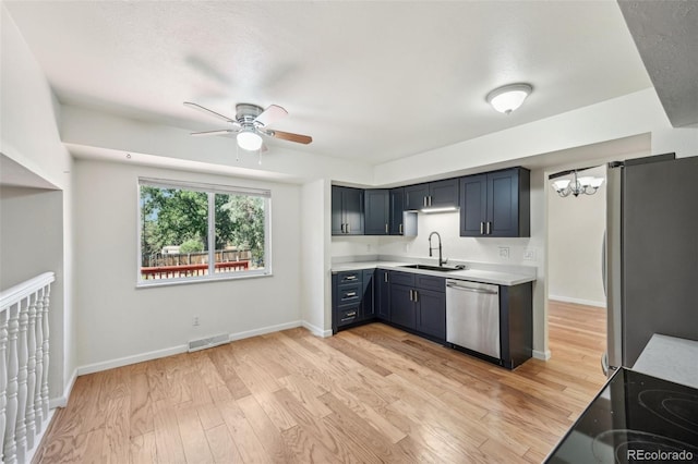 kitchen featuring ceiling fan with notable chandelier, appliances with stainless steel finishes, sink, and light wood-type flooring