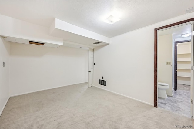 basement with light colored carpet and a textured ceiling