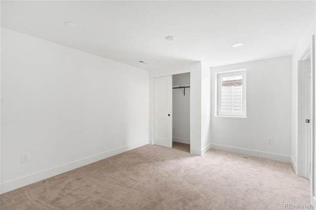 unfurnished bedroom with a closet and light carpet