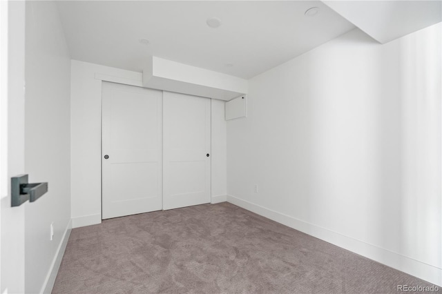 unfurnished bedroom featuring light colored carpet and a closet