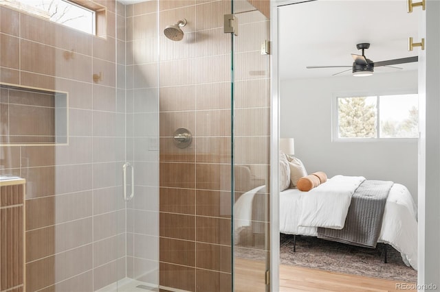 bathroom with hardwood / wood-style floors, ceiling fan, and walk in shower