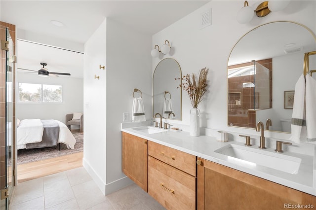 bathroom with walk in shower, ceiling fan, vanity, and tile patterned flooring