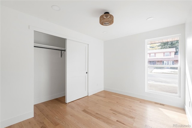 unfurnished bedroom featuring light hardwood / wood-style floors and a closet