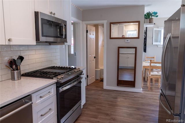 134 S Quitman St, Denver, CO 80219 - kitchen featuring appliances with stainless steel finishes, white cabinetry, backsplash, wood finished floors, and light stone counters