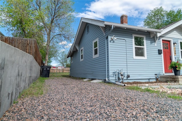 134 S Quitman St, Denver, CO 80219 - view of side of home with a chimney and fence