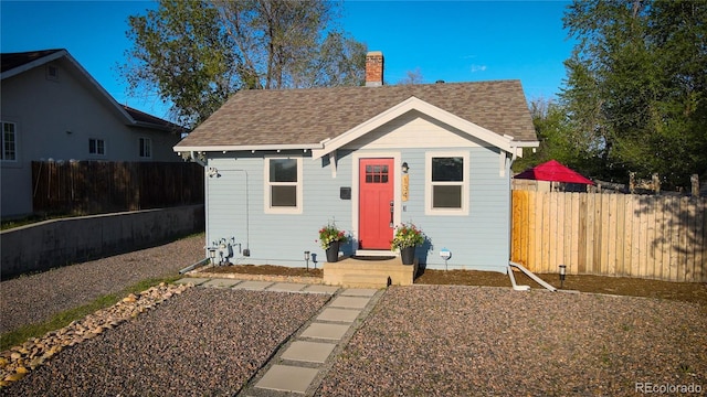 134 S Quitman St, Denver, CO 80219 - view of front facade featuring roof with shingles, a fenced backyard, and an outdoor structure