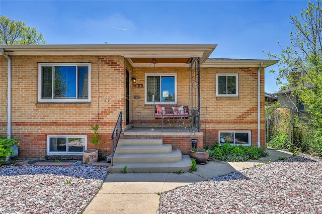 view of front of home featuring brick siding and covered porch