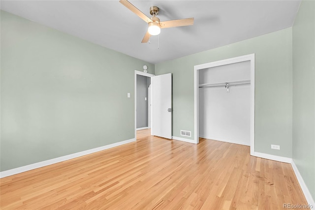 unfurnished bedroom with wood finished floors, baseboards, a closet, and a ceiling fan