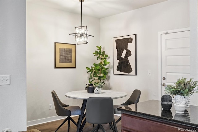 dining area featuring a chandelier and dark wood-type flooring