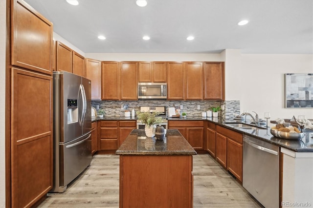 kitchen featuring tasteful backsplash, light hardwood / wood-style flooring, kitchen peninsula, a kitchen island, and appliances with stainless steel finishes