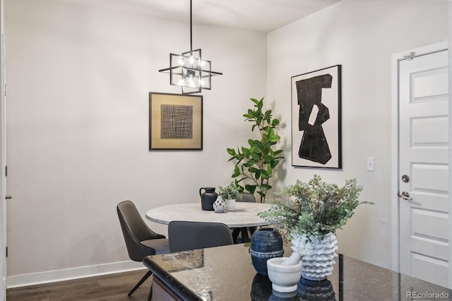 dining space featuring dark hardwood / wood-style flooring and an inviting chandelier