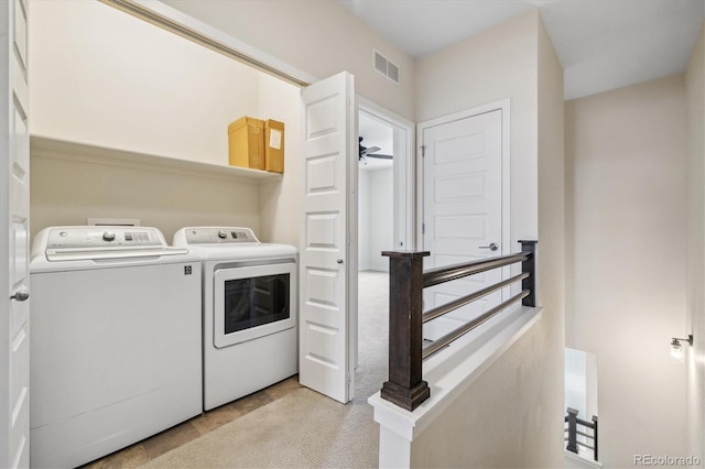 clothes washing area with ceiling fan, independent washer and dryer, and light carpet