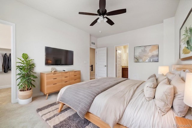 carpeted bedroom with a closet, ensuite bath, and ceiling fan