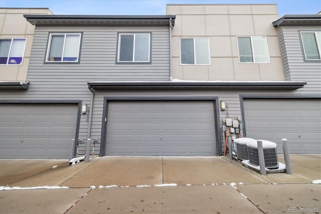 view of front of property featuring central AC unit and a garage