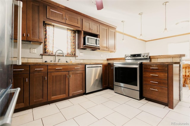 2535 W Bijou St, Colorado Springs, CO 80904 - kitchen featuring decorative light fixtures, ornamental molding, a sink, a peninsula, and appliances with stainless steel finishes