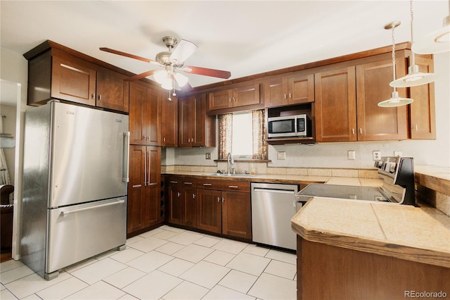 2535 W Bijou St, Colorado Springs, CO 80904 - kitchen featuring a sink, tile counters, pendant lighting, ceiling fan, and appliances with stainless steel finishes