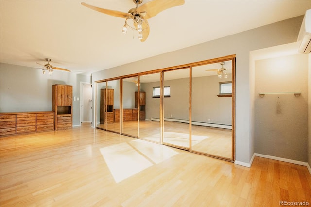 2535 W Bijou St, Colorado Springs, CO 80904 - unfurnished bedroom featuring baseboards, baseboard heating, a wall unit AC, and wood finished floors