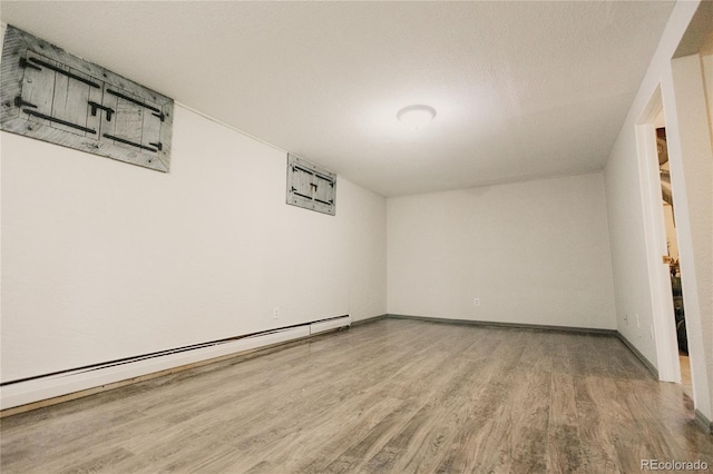 2535 W Bijou St, Colorado Springs, CO 80904 - empty room featuring a baseboard heating unit, baseboards, and wood finished floors