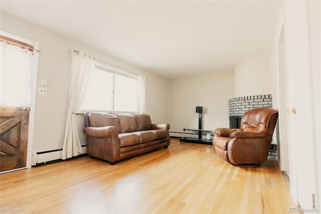 2535 W Bijou St, Colorado Springs, CO 80904 - living area featuring a baseboard radiator, light wood-style flooring, and a fireplace