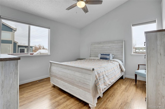 bedroom featuring light wood-type flooring, baseboards, and vaulted ceiling