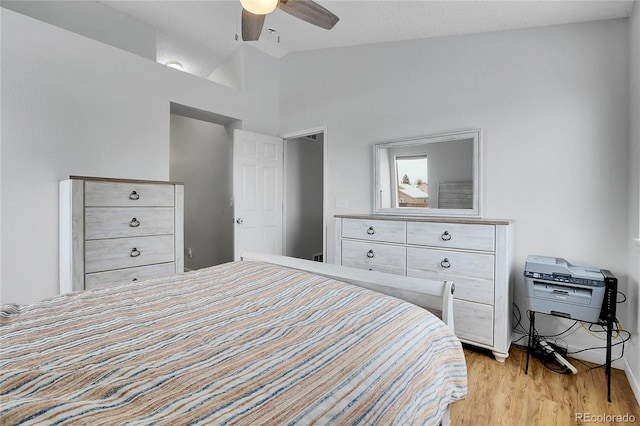 bedroom with light wood-style floors, lofted ceiling, and a ceiling fan