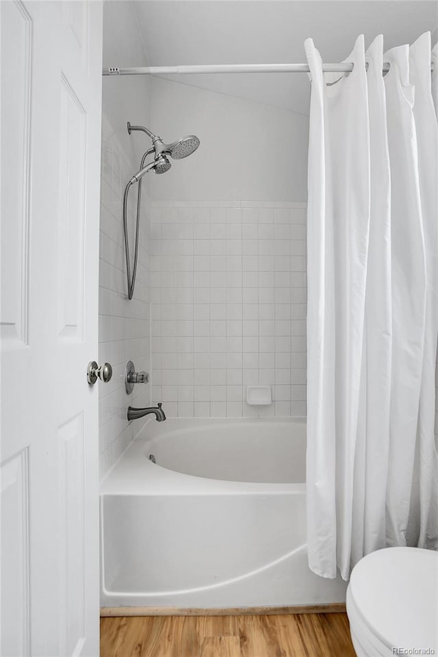 full bathroom featuring shower / bath combo with shower curtain, toilet, and wood finished floors