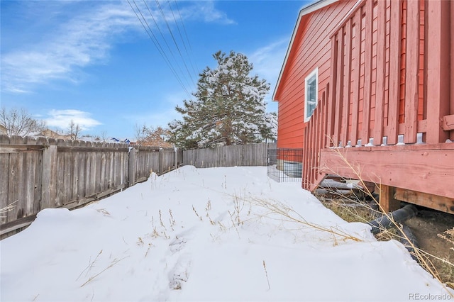 yard covered in snow featuring a fenced backyard