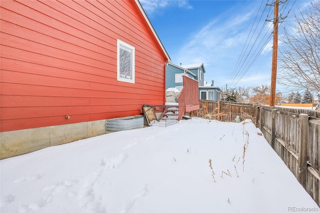 snowy yard featuring fence