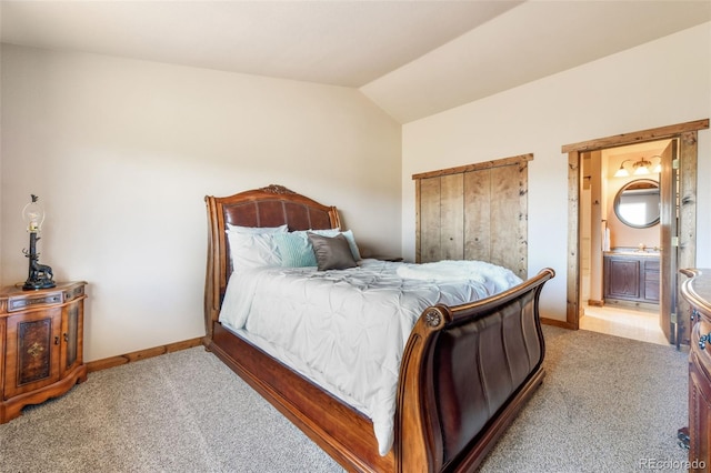 631 County Road 61, Cripple Creek, CO 80813 - bedroom with light colored carpet, baseboards, vaulted ceiling, and ensuite bath
