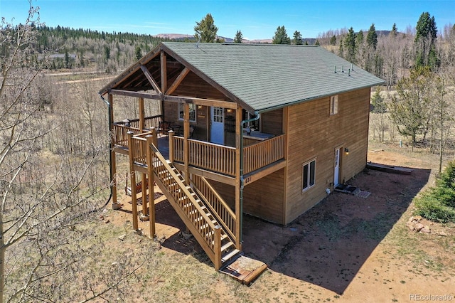 631 County Road 61, Cripple Creek, CO 80813 - view of front of home featuring a wooden deck, stairway, and a forest view