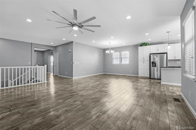 6932 E 133rd Ave, Thornton, CO 80602 - unfurnished living room featuring a ceiling fan, a chandelier, dark wood-style flooring, and recessed lighting
