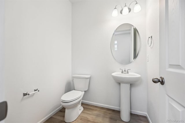 bathroom with sink, hardwood / wood-style flooring, and toilet