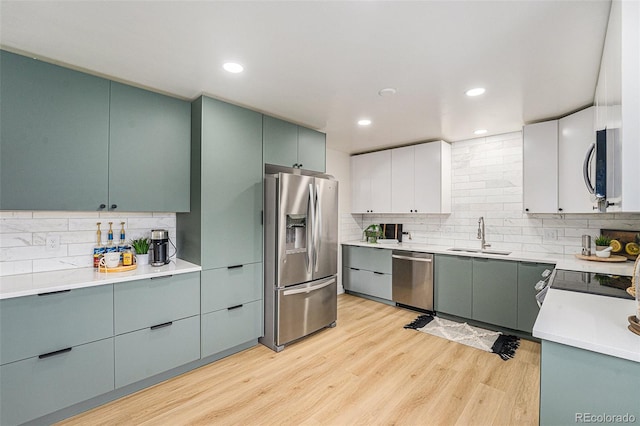 6513 Gray St, Arvada, CO 80003 - kitchen with stainless steel appliances, tasteful backsplash, light wood-type flooring, light countertops, and recessed lighting