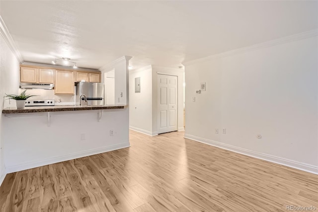 kitchen with a kitchen breakfast bar, stainless steel refrigerator, stove, light hardwood / wood-style flooring, and ornamental molding