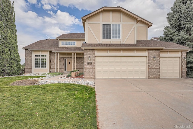 tudor-style house featuring a front yard and a garage