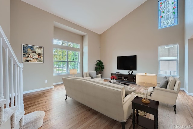 living room with light hardwood / wood-style flooring and high vaulted ceiling