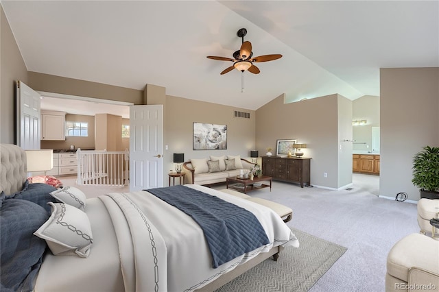 carpeted bedroom featuring ceiling fan, vaulted ceiling, and ensuite bathroom