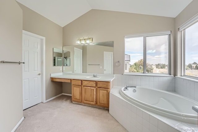 bathroom with vanity, lofted ceiling, and tiled tub